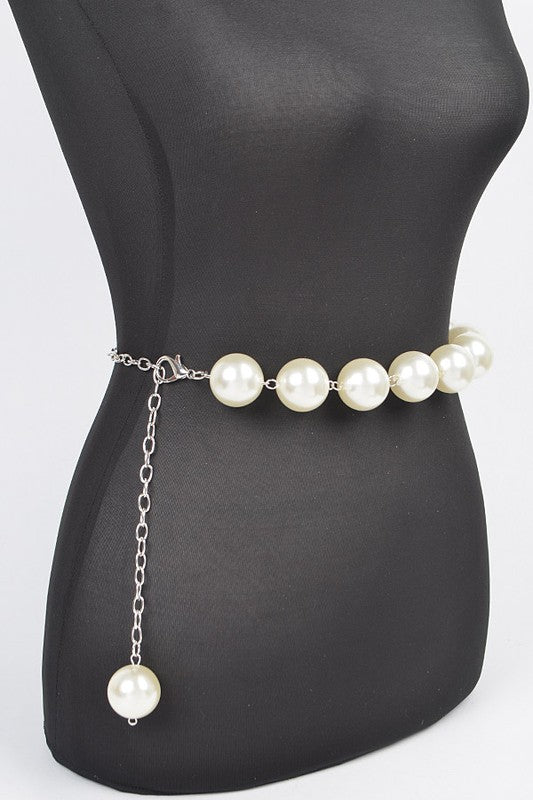 Pearl chain belt on a mannequin waist with a plain background
