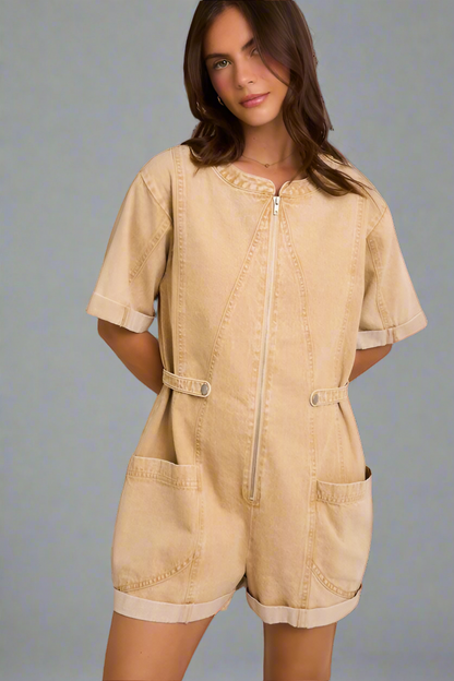 Woman wearing a beige romper on a neutral background