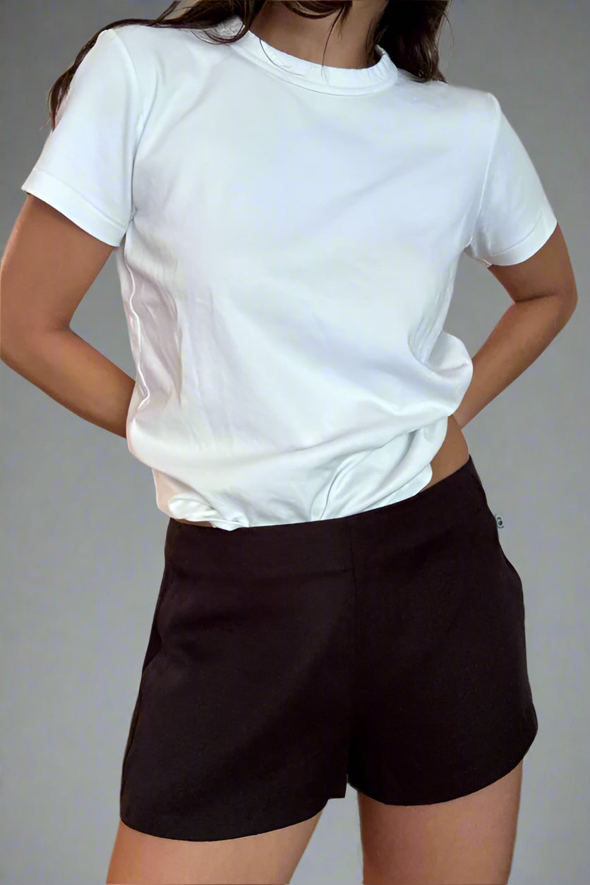 Person wearing a white t-shirt and black shorts against a plain background