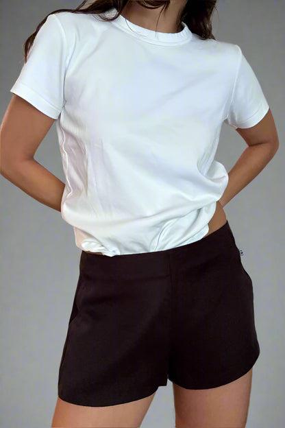 Person wearing a white t-shirt and black shorts against a plain background