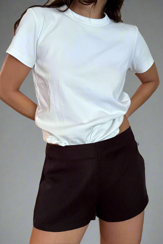 Person wearing a white t-shirt and black shorts against a plain background